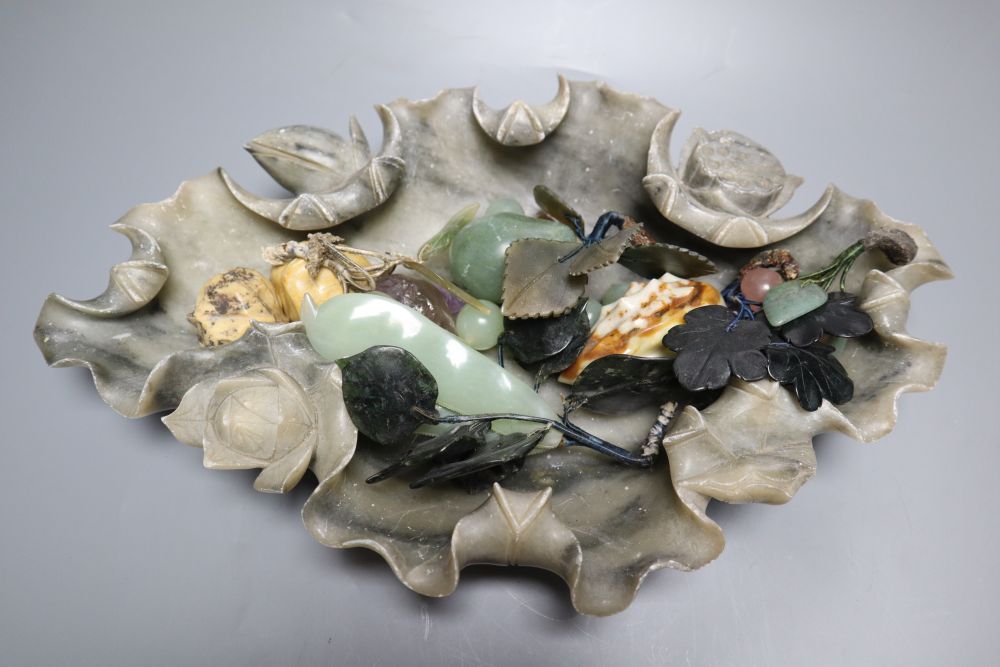 A Chinese soapstone lotus dish containing hardstone models of fruit and a hardstone model of flowers